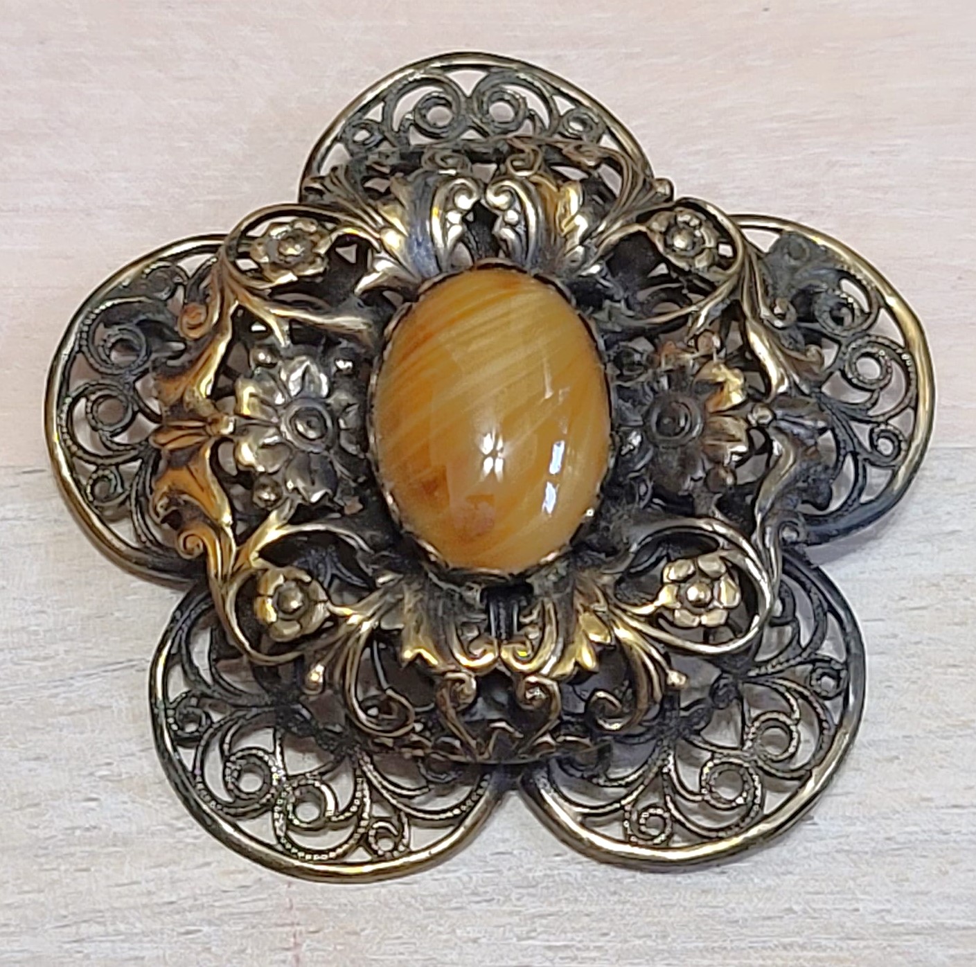 Vintage brass pin with butterscotch cabachon center, filigre design