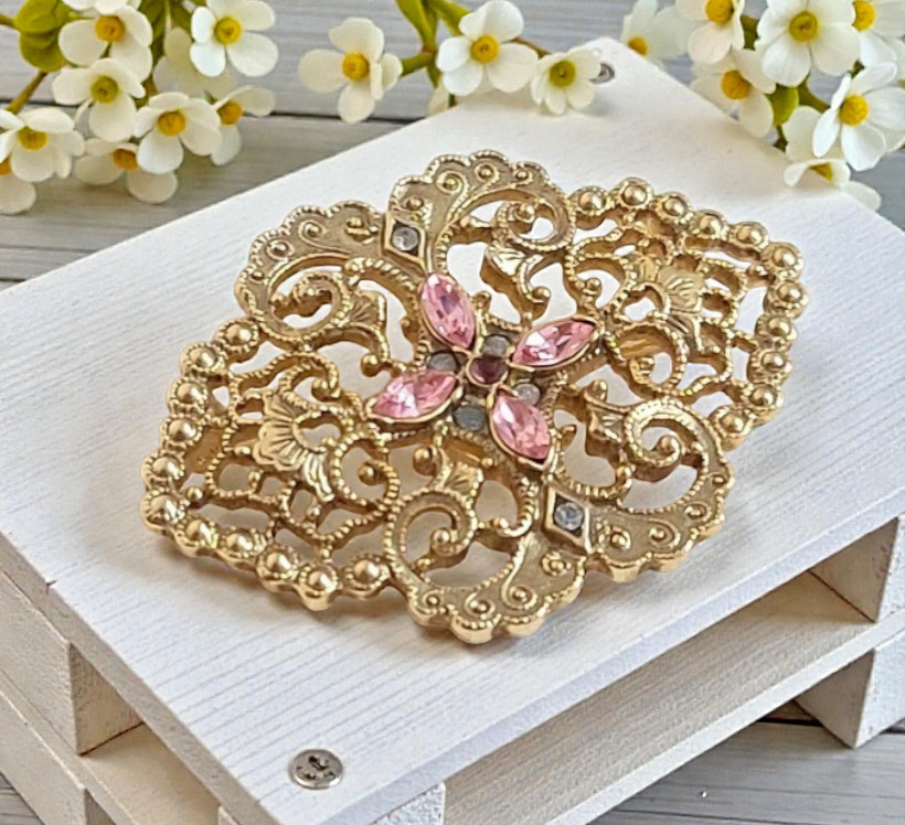 Pink rhinestone pin with a filigree design