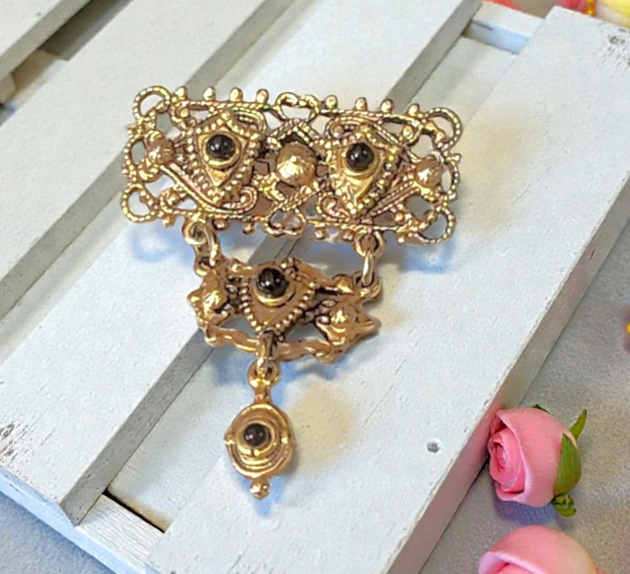 Shield pin with black cabochons