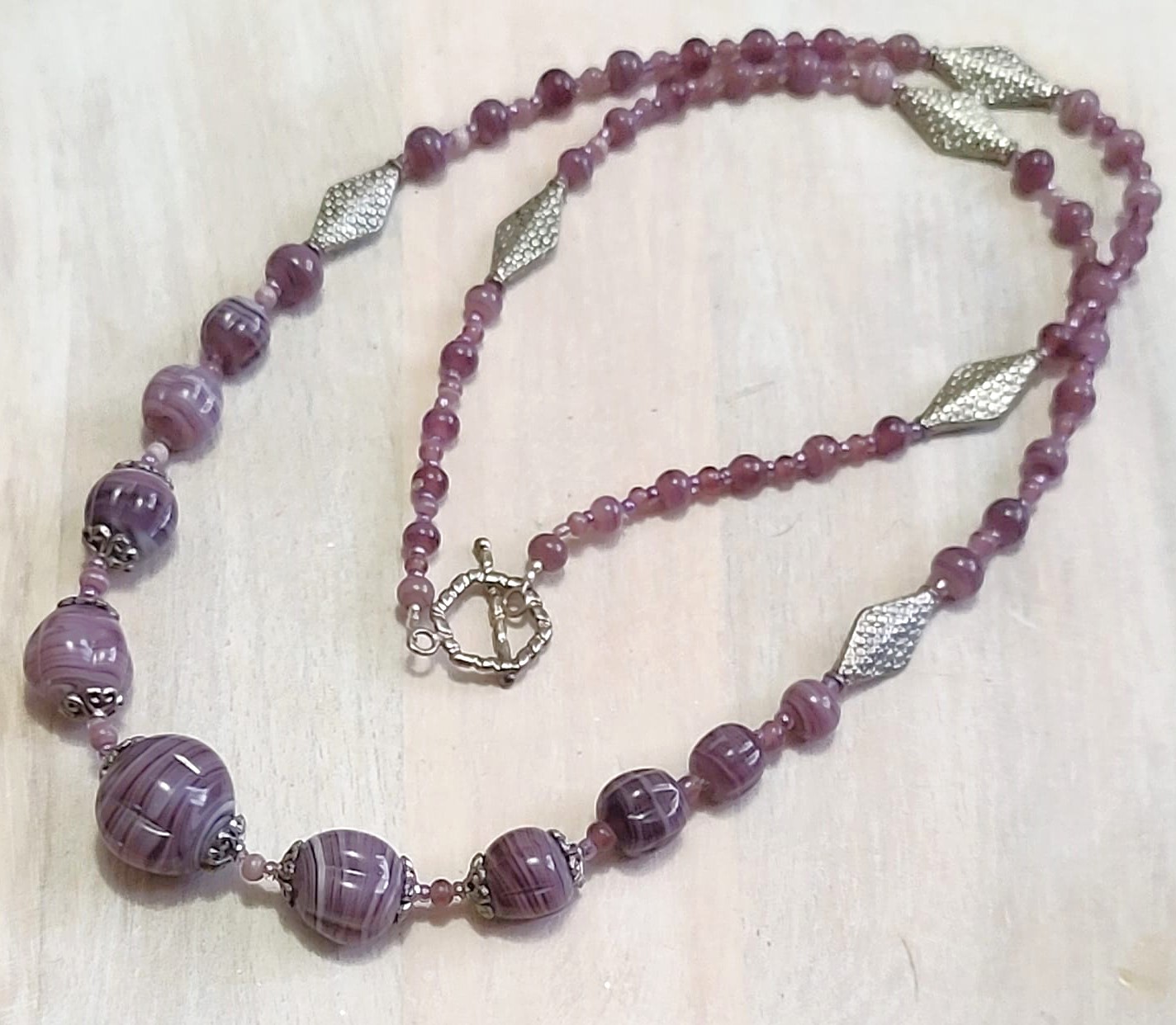 Purple swirl glass bead necklace with textured silver plated diamond shape accents, handcrafted necklace