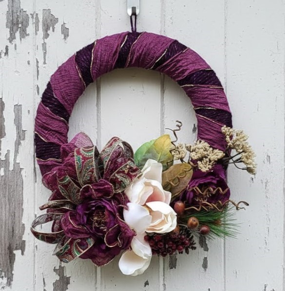 Purple floral wreath with magnolia flowers and baby's breath arrangement